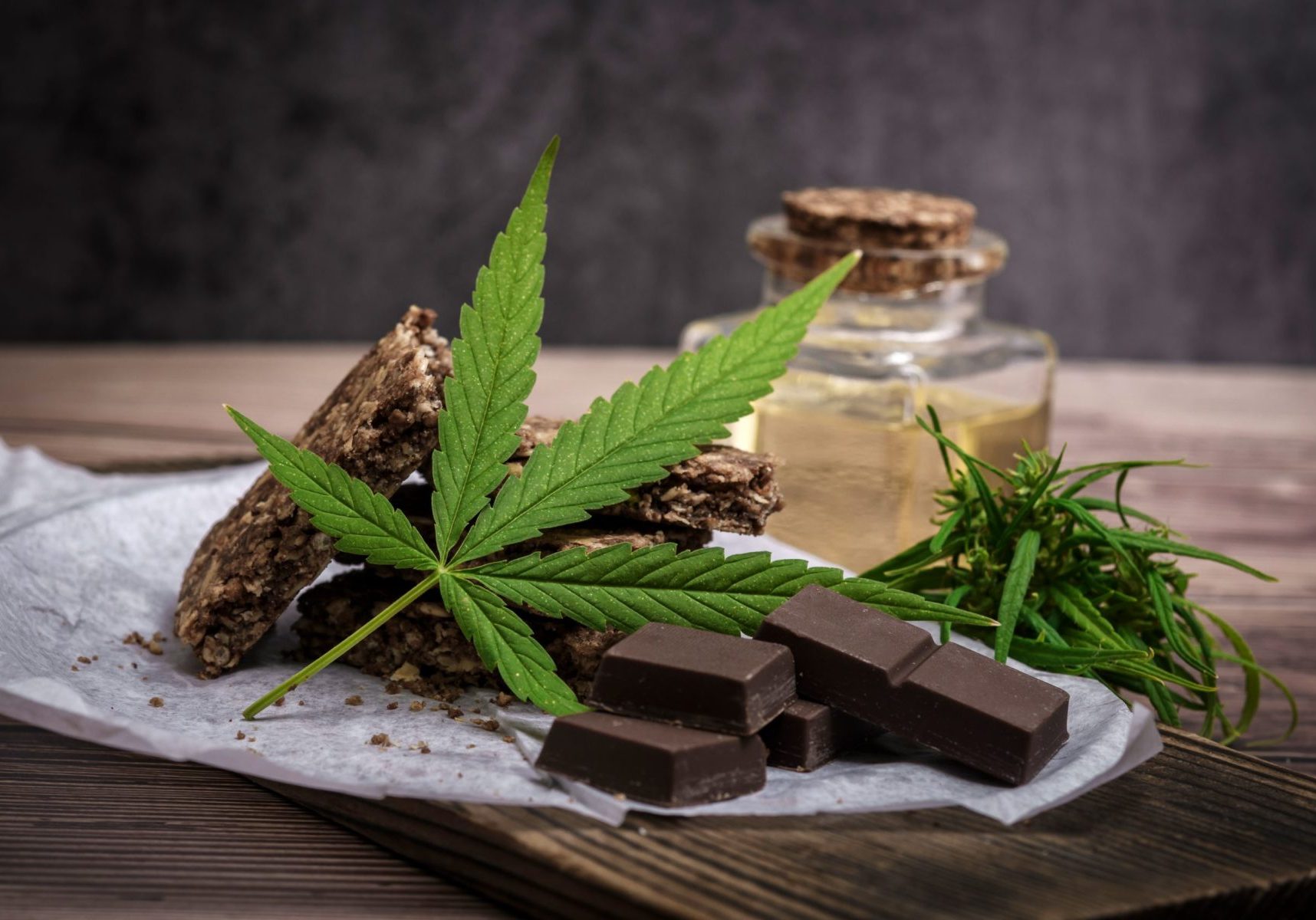 Marijuana leaf and cereal crunchy multigrain chocolate on brown wooden background.